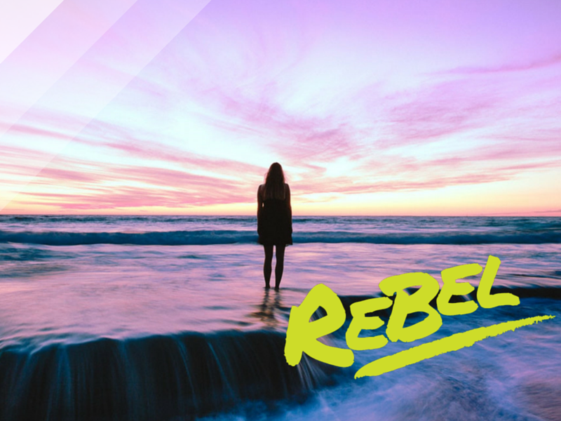 Solitary figure on shore at sunset with vibrant sky, 'REBEL' text overlay, self-discovery theme.